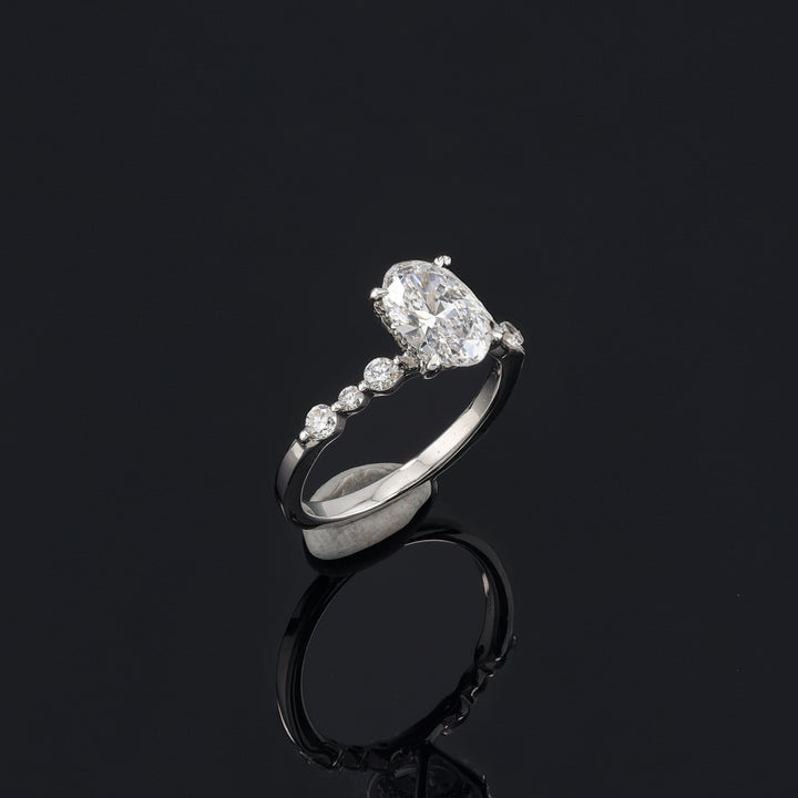 Oval Ring with sparkling oval centerpiece and side diamonds, showcasing timeless elegance and brilliance by the jewelry store.